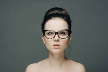 Çıplak omuzlu, güzel esmer bir kadının portresi şık bir saç modeli.