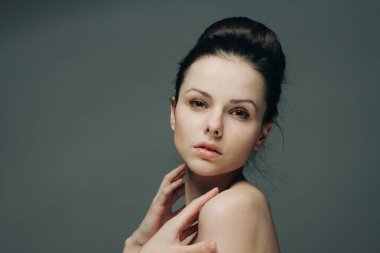 Güzel esmer, şık saç stili, çıplak omuzlu temiz cilt kozmetolojisi.