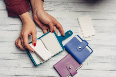 İş kartları için cüzdanları olan ahşap masa, kadın eli finans.