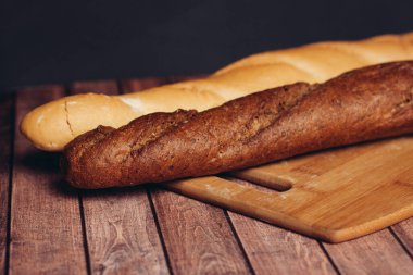 Taze gevrek somun, tahta bıçak, ahşap masa unu ürünü.