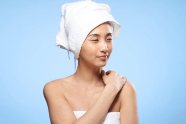 Güzel bir kadın çıplak omuzlu. Başında sağlık havlusu var.