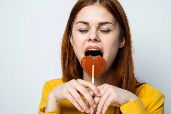 Attraktive Frau leckt lutschgelbes Hemd Emotionen in Nahaufnahme — Stockfoto