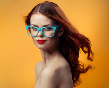 Çıplak omuzlu çekici bir kadın. Kırmızı dudaklar. Yakın plan mavi gözlükler.