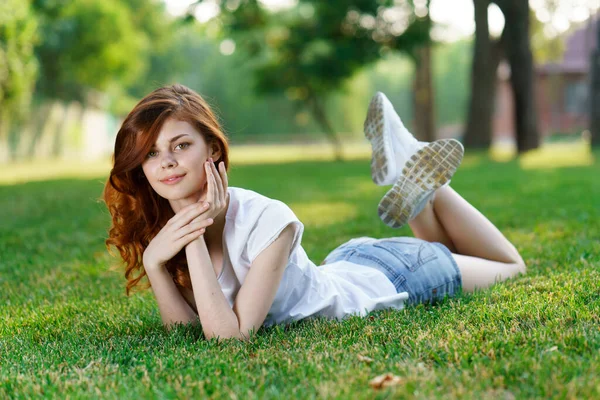 Frau liegt im Park auf dem Rasen an der frischen Luft — Stockfoto