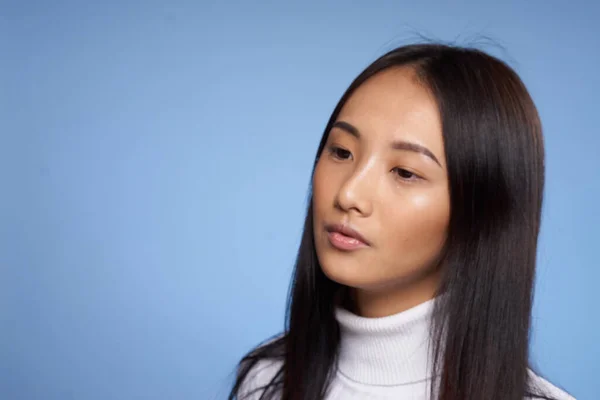 Kvinna asiatisk utseende vit jumper blå bakgrund närbild modell — Stockfoto