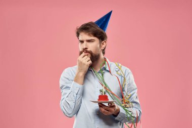 Pembe arka planda mumu olan pastalı bir adamın doğum günü.