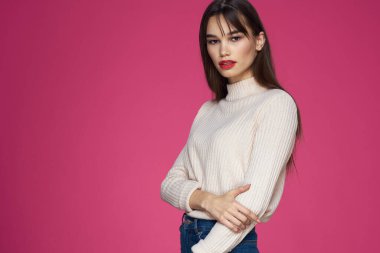 Güzel esmer, uzun saçlı, şık, zarif, pembe arka planlı.