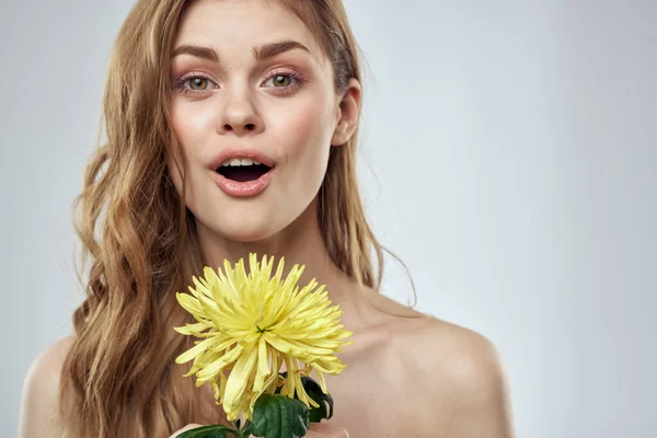 Charmante dame avec fleur jaune sur un fond clair vue recadrée — Photo