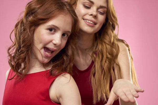 Äiti ja tytär hauskaa viestintä perheen iloa vaaleanpunainen tausta rajattu näkymä — kuvapankkivalokuva