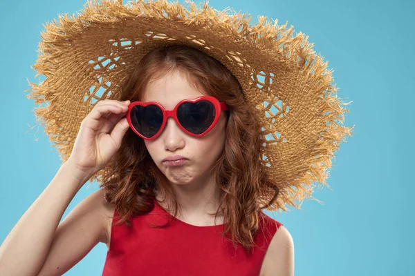 Chica en una playa Sombrero de paja en gafas de sol pelo rizado divertido fondo azul — Foto de Stock