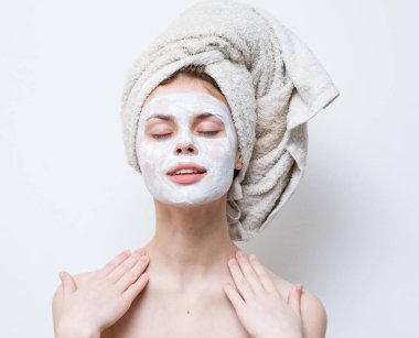 Yüz havlusunda kremi olan kadın.