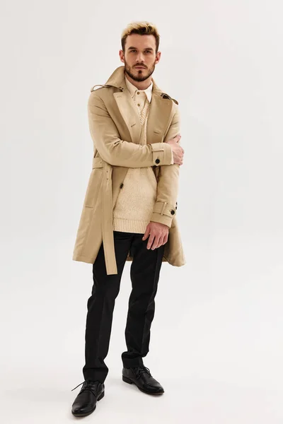 Hombre guapo en abrigo moda otoño estilo estudio luz fondo — Foto de Stock