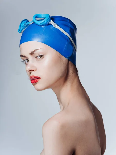 Retrato de uma mulher nadadora em um boné azul e óculos na cabeça desnudados ombros — Fotografia de Stock