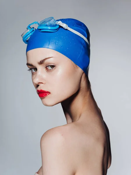 一个戴着蓝色泳帽的漂亮女人的画像，红唇，双肩朝侧看 — 图库照片