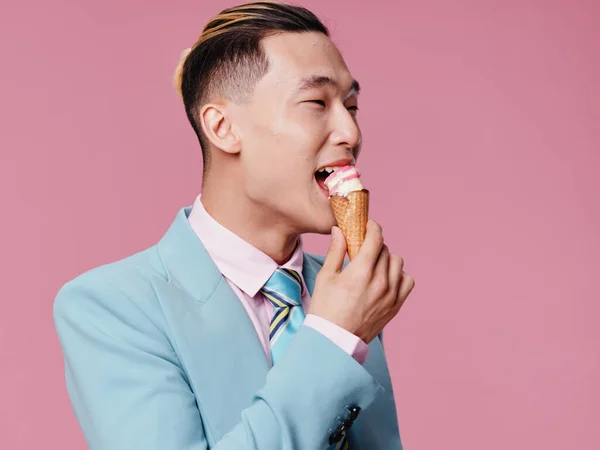 Aranyos férfi ázsiai megjelenés kék ruha fagylalt élvezet rózsaszín háttér — Stock Fotó