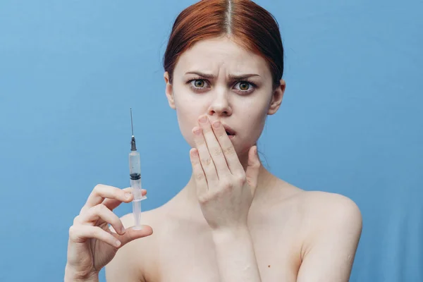 Mujer dando inyección y desnudo hombros asustado cara fondo azul — Foto de Stock