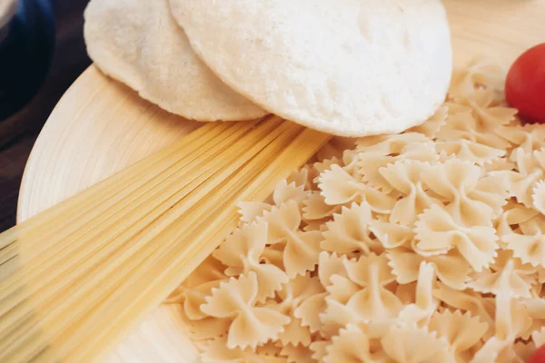 Italiaanse pasta met de hand kerstomaten houten tafel — Stockfoto