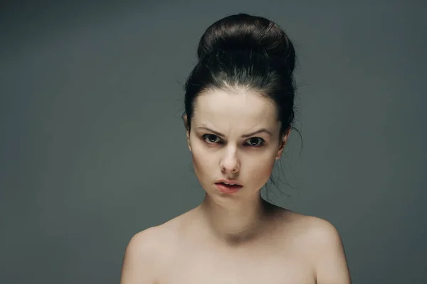 Женщина с голыми плечами на сером фоне чистой косметологии ухода за кожей красоты — стоковое фото