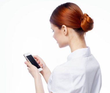 Beyaz tişörtlü kadın elinde telefonla internet iletişimi.