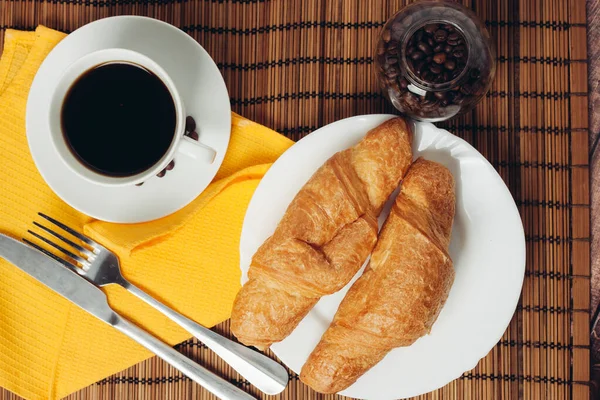 Croissant en un plato en la mesa comida de desayuno utensilios de cocina —  Fotos de Stock
