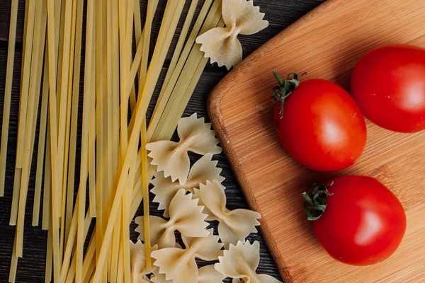 Italiaanse pasta op een houten tafel kerstomaten koken — Stockfoto