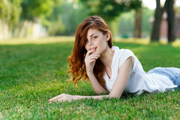 Frau liegt im Park auf dem Rasen an der frischen Luft — Stockfoto