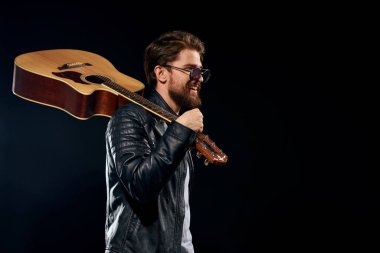 Elinde gitar olan bir adam deri ceketli müzik performansı rock yıldızı modern tarz koyu arkaplan