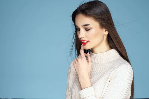 Morena em uma camisola branca lábios vermelhos charme cabelos longos fundo azul — Fotografia de Stock