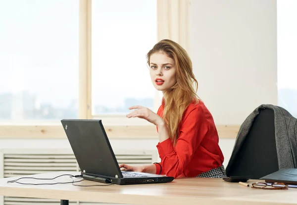 Mulher secretária camisa vermelha mesa de trabalho laptop gerente de escritório — Fotografia de Stock