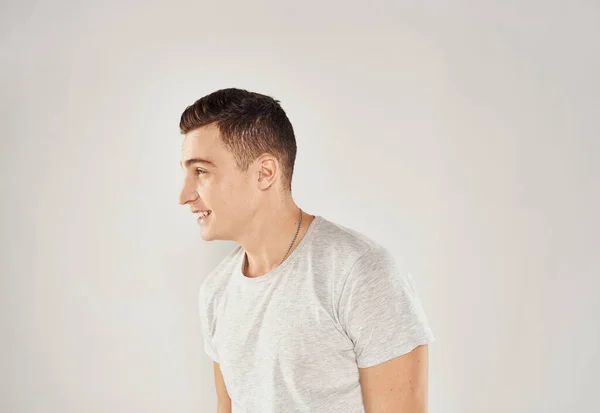 Homem em branco t-shirt emoções estúdio recortado vista luz fundo — Fotografia de Stock