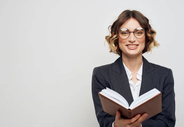Donna in abito classico con occhiali da libro aperti sul viso vista ritagliata su sfondo chiaro — Foto Stock