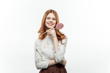 Ellerinde lolipopları olan kızıl saçlı güzel bir kadın.