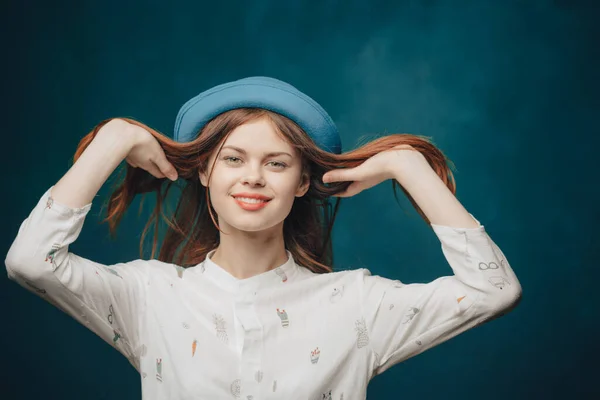 Emotionell kvinna i blå hatt gest med händer rött hår blond tröja — Stockfoto
