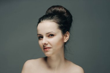 Gri arka planda güzel esmer çıplak omuzlar temiz cilt kozmetolojisi