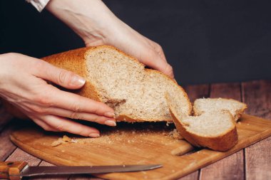 Kesme tahtasındaki taze bir somunu dilimliyorum.