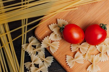 Elle İtalyan makarnası pişirmek mutfak kiraz domatesleri öğle yemeği malzemeleri.