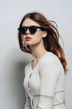 Güneş gözlüklü bir kadın, bol saçlı stüdyo tarzı.