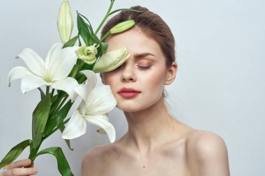 Gri arkaplanda beyaz çiçekli kadın portresi yakın çekim makyaj modu