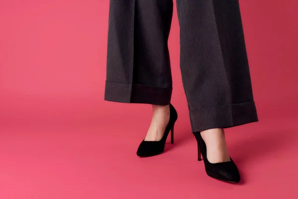 Жіночі ноги чорне взуття гламурний розкішний рожевий фон обрізаний вид — стокове фото