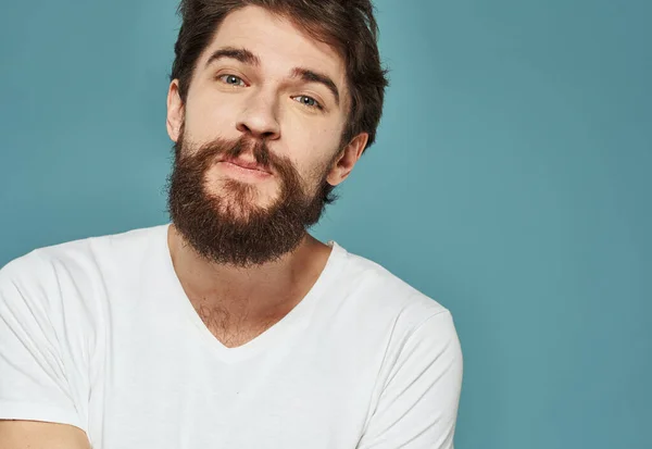 Portret van een man blauwe achtergrond close-up bijgesneden uitzicht wit t-shirt knappe glimlach — Stockfoto