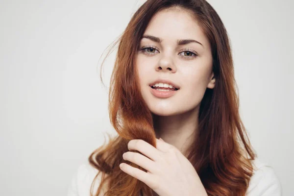 Mulher feliz com escova de cabelo no fundo claro e cabelo saudável — Fotografia de Stock