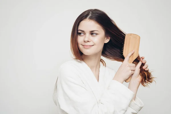 Γυναίκα με λευκή ρόμπα με ξύλινη χτένα και μακριά μαλλιά μοντέλο — Φωτογραφία Αρχείου