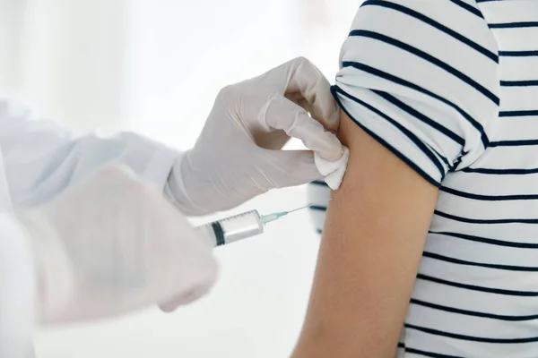 Läkaren injicerar vaccinet i patientens hand — Stockfoto