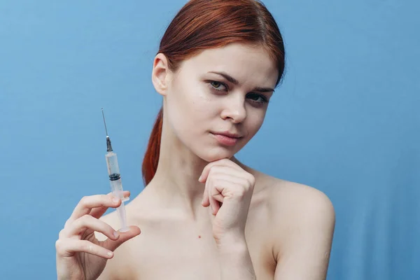 Jeringa en mano de mujer sobre fondo azul inyección rejuvenecimiento botox vista recortada — Foto de Stock