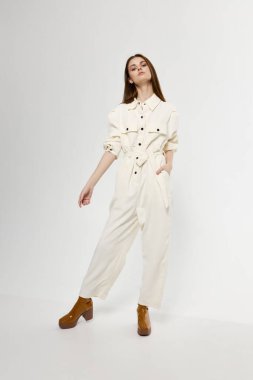 Tulum giymiş güzel bir kadın, elleri hafif bir arka planda, tam gelişim içinde el kol hareketi yapıyor.