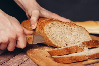 Tahta kesme tahtasında dilimlenmiş taze somun ekmek.