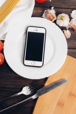 Telefon bir tabakta bıçakla doğranır ve ahşap masa yenir.