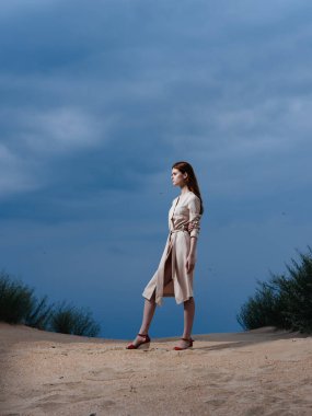 Sahilde kırmızı sandaletlerle uzun adımlarla yürüyen bir kadın.