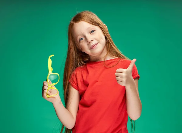 Χαριτωμένο κορίτσι κόκκινα μαλλιά συναισθήματα μάθηση σχολείο πράσινο φόντο — Φωτογραφία Αρχείου
