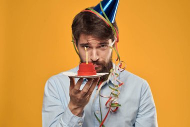 Bir adam bir tabakta pasta tutuyor ve yukarıdan izole edilmiş bir arkaplan mumu.